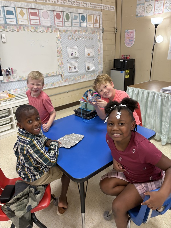 2nd  grade students working on aluminum foil boats
