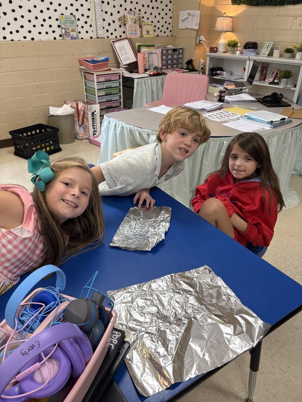 2nd  grade students working on aluminum foil boats