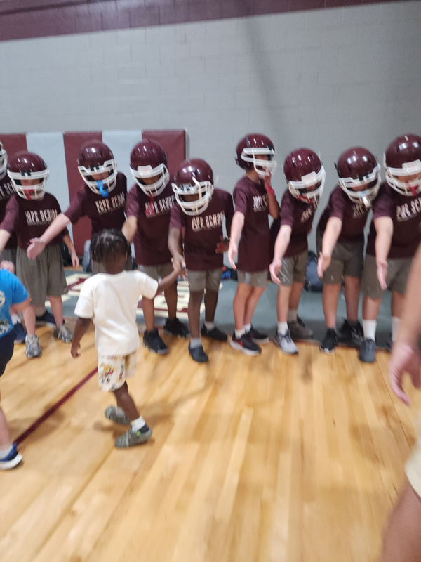 PreK students high fiving football players