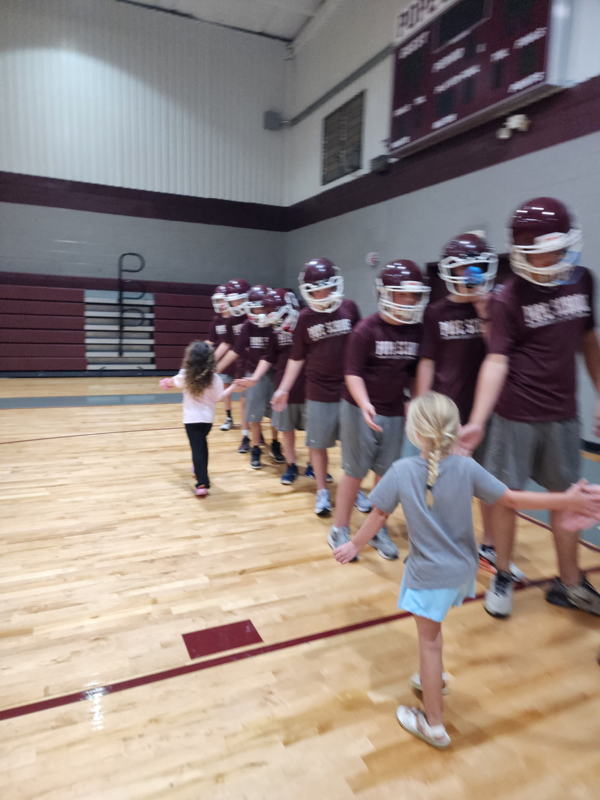 PreK students high fiving football players