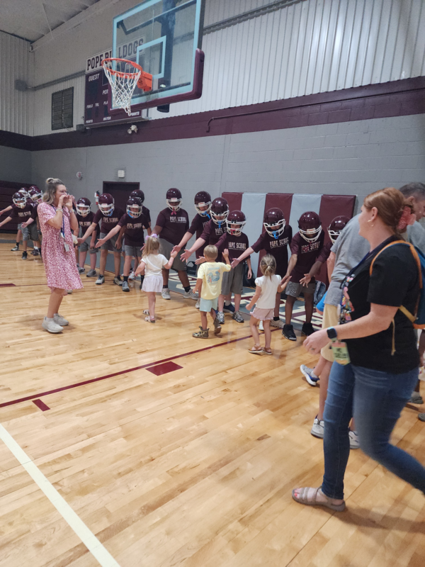 PreK students high fiving football players