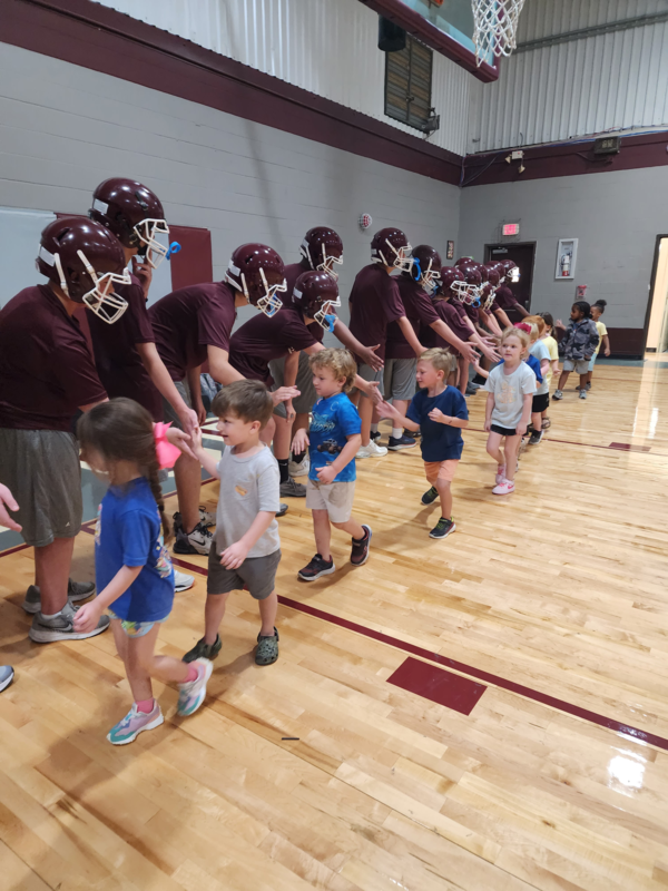 PreK students high fiving football players