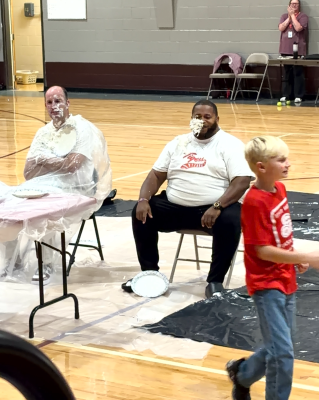 Elementary students holding pies