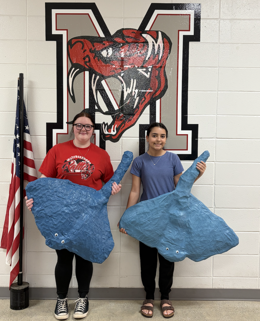 Bella White and Morgan Bierden holding their sting rays.