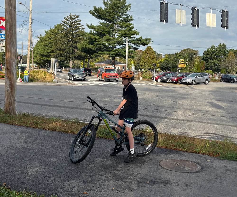 Jack Hoyt, a sixth grader, waits before continuing his ride to school along the new neighborhood byway in South Portland. (Dana Richie/Staff Writer)