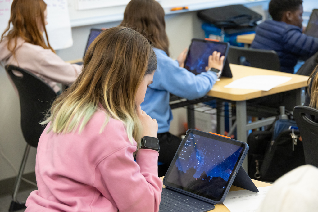 Students using their devices to track constellations throughout the year.