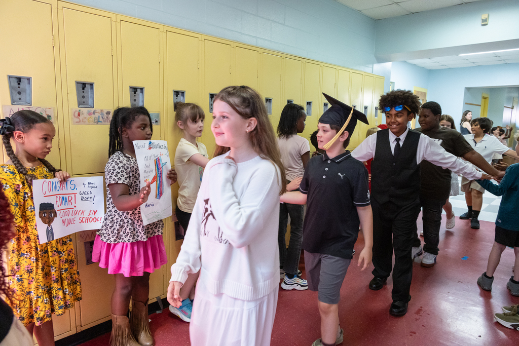 Skillin Elementary students walk the halls as other grades cheer them on before receiving their certificates for completing fourth grade.