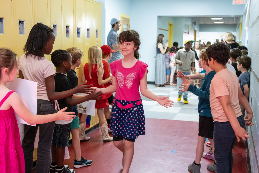 Skillin Elementary students walk the halls as other grades cheer them on before receiving their certificates for completing fourth grade.