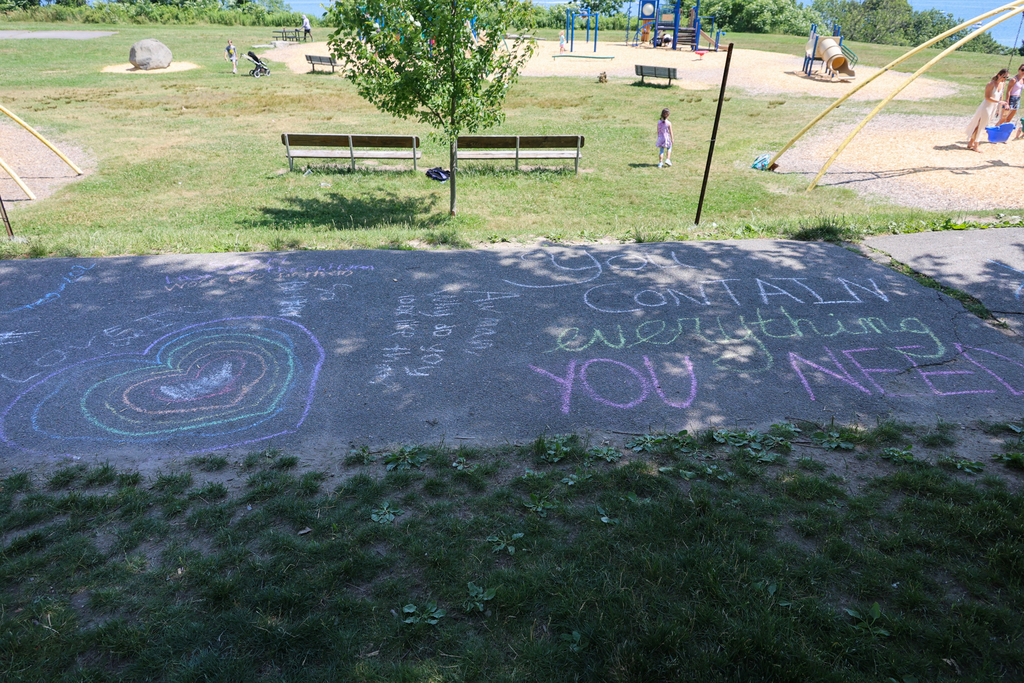 Students writing messages with chalk on the sidewalks at the Eastern Promenade
