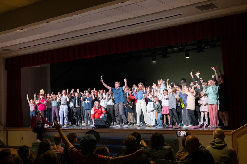 SPMS Talent Show & Fundraiser - staff member inviting students on stage to sing a song