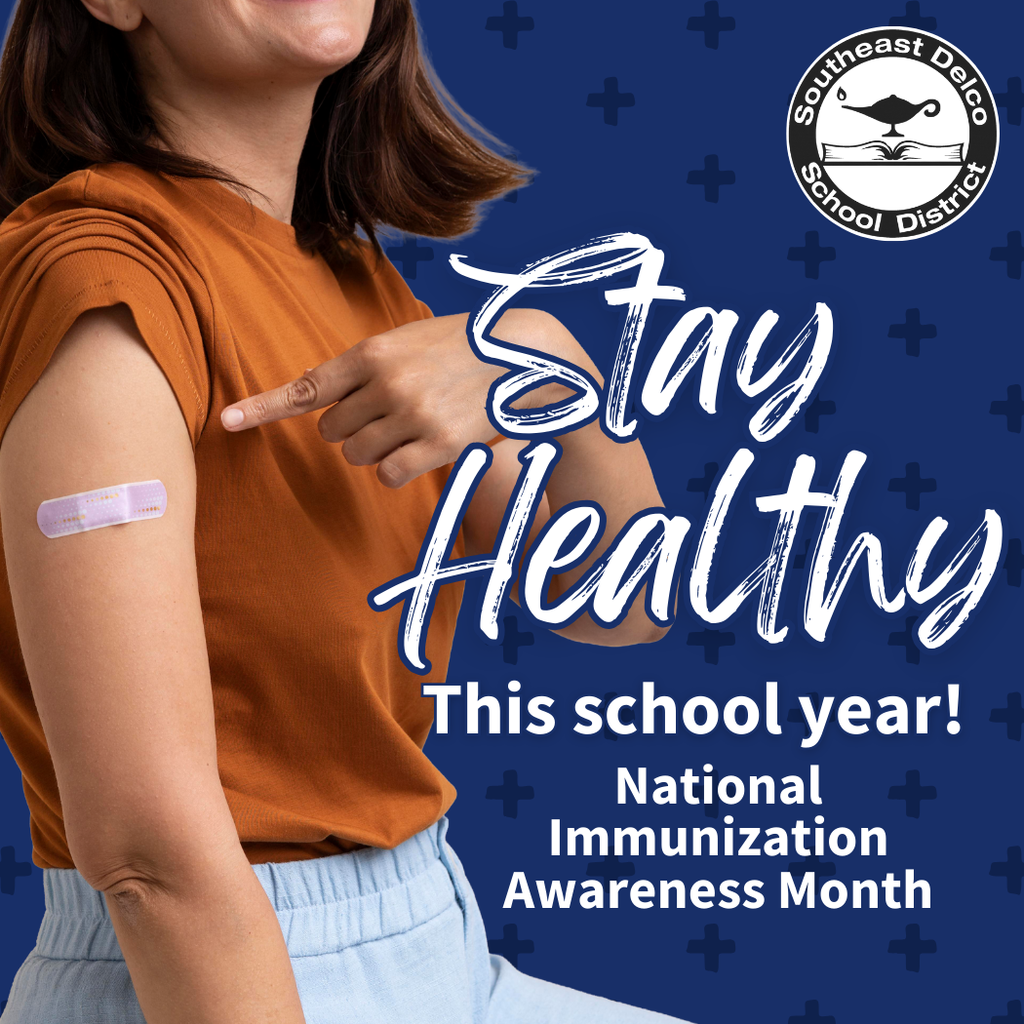 A person in an orange shirt smiles while pointing to a bandage on their upper arm, symbolizing vaccination. Bold white and blue text reads, “Stay Healthy This school year! National Immunization Awareness Month.” The background is dark blue with plus signs, and the Southeast Delco School District logo appears in the top right corner.