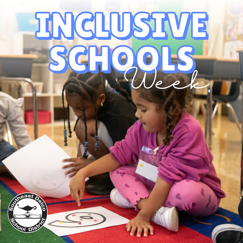 A young girl in a purple outfit sits on a colorful classroom rug, smiling as she points to a paper with a large number “6” decorated with small stickers. Another child beside her leans in to look at the activity. The text “Inclusive Schools Week” appears above them, and the Southeast Delco School District logo is in the lower-left corner.