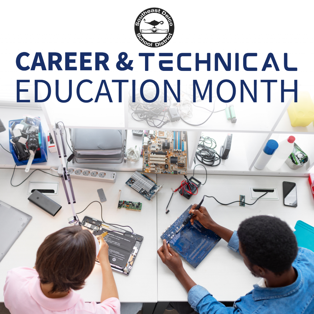 Two students working on electronic circuit boards at a table during Career & Technical Education Month activities.