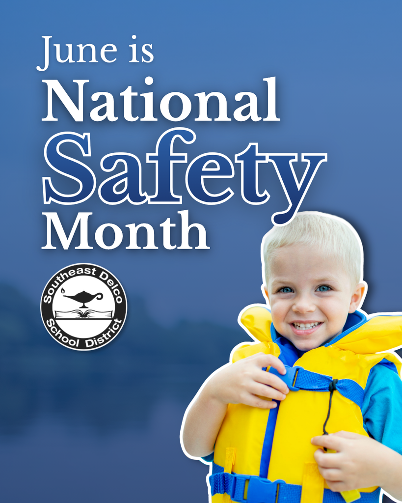 Young child wearing a bright yellow life jacket by a calm lake, emphasizing water safety during National Safety Month in June.