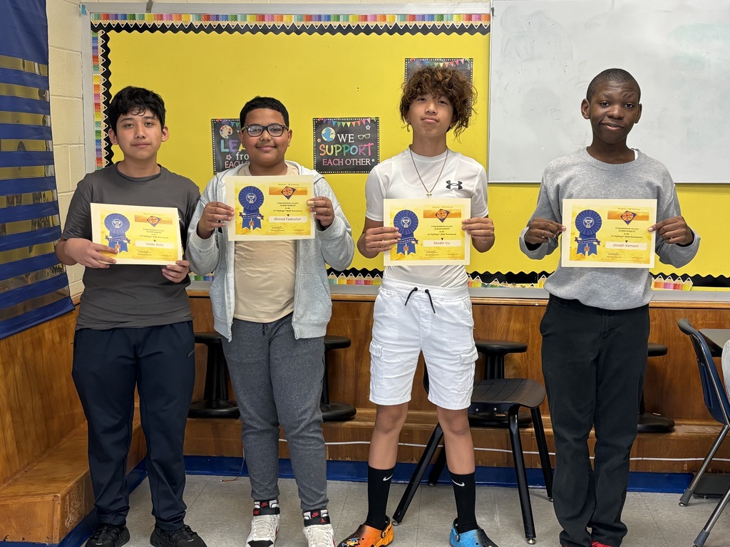 Four students hold Math 24 Challenge achievement certificates while posing in a classroom.