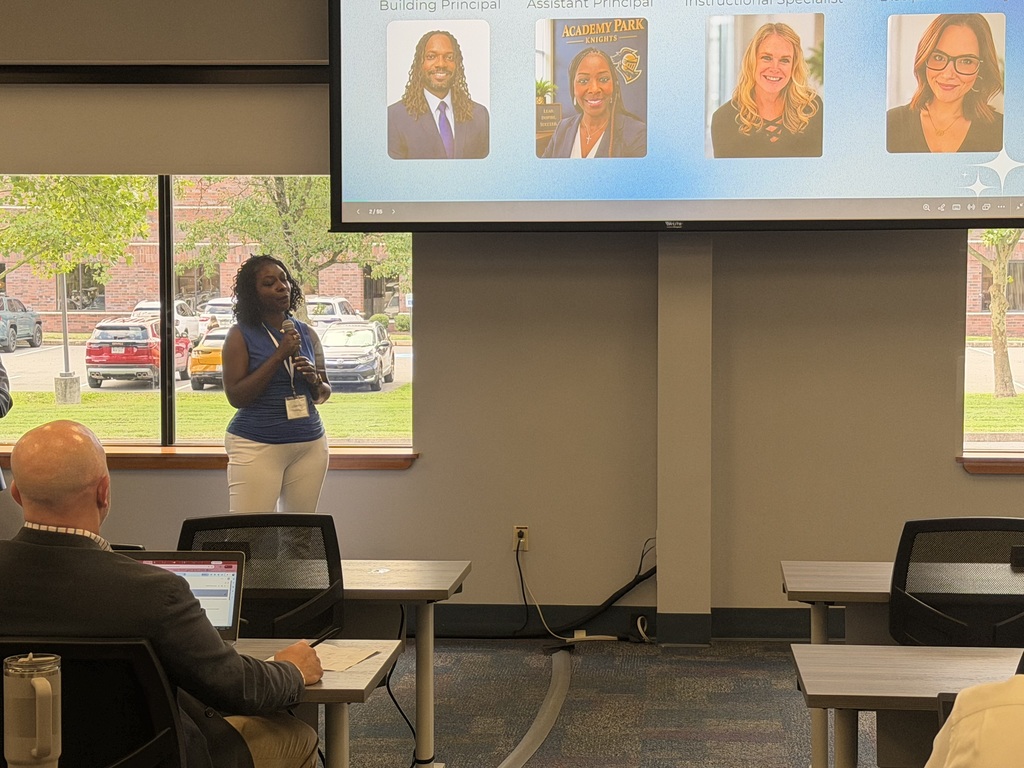 Guest speaker shares school leadership strategies while presenting photos of an administrative team to workshop participants.
