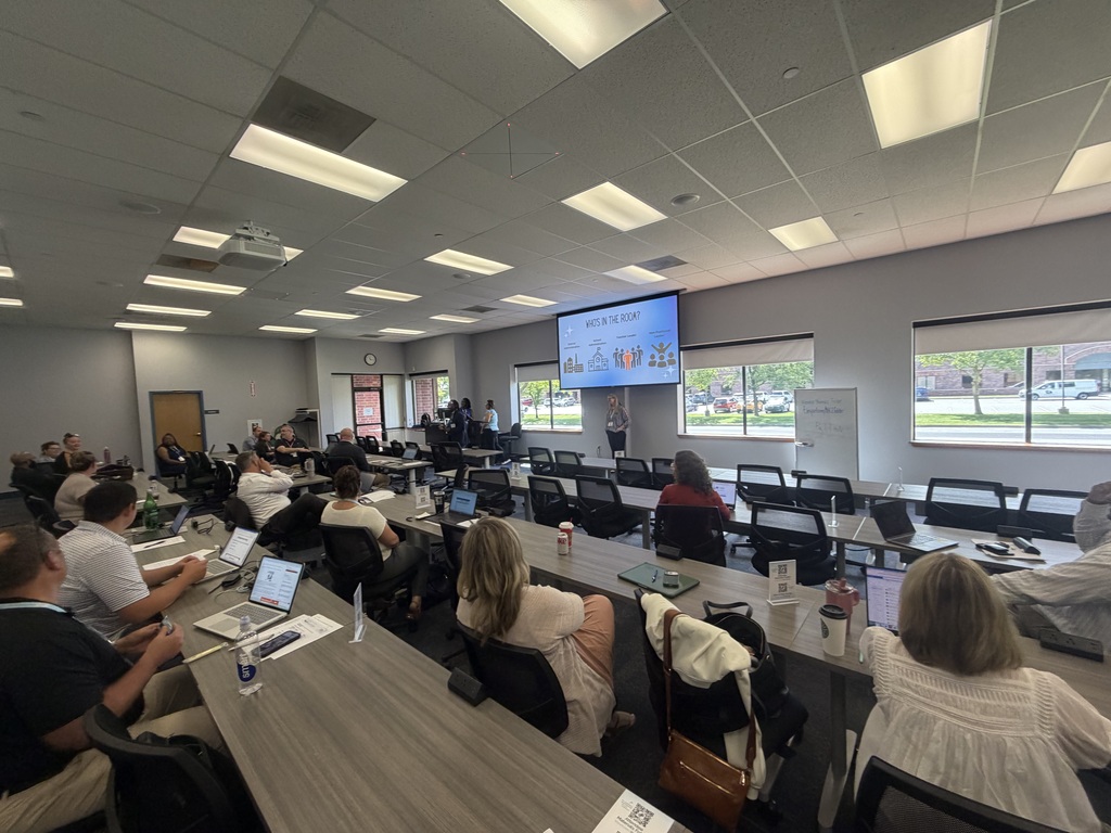 Educators attend a professional learning session in a conference room as presenters lead a discussion on school leadership and MTSS practices.