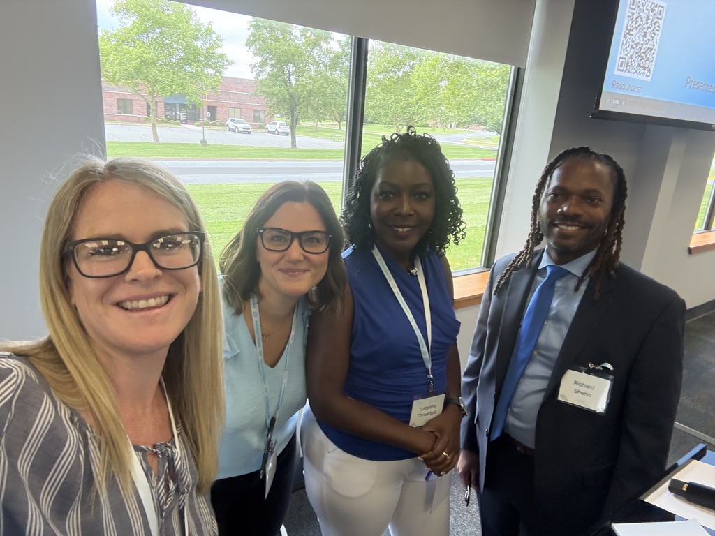 Four educators smile for a group photo during a professional learning session after presenting on school leadership and MTSS practices.