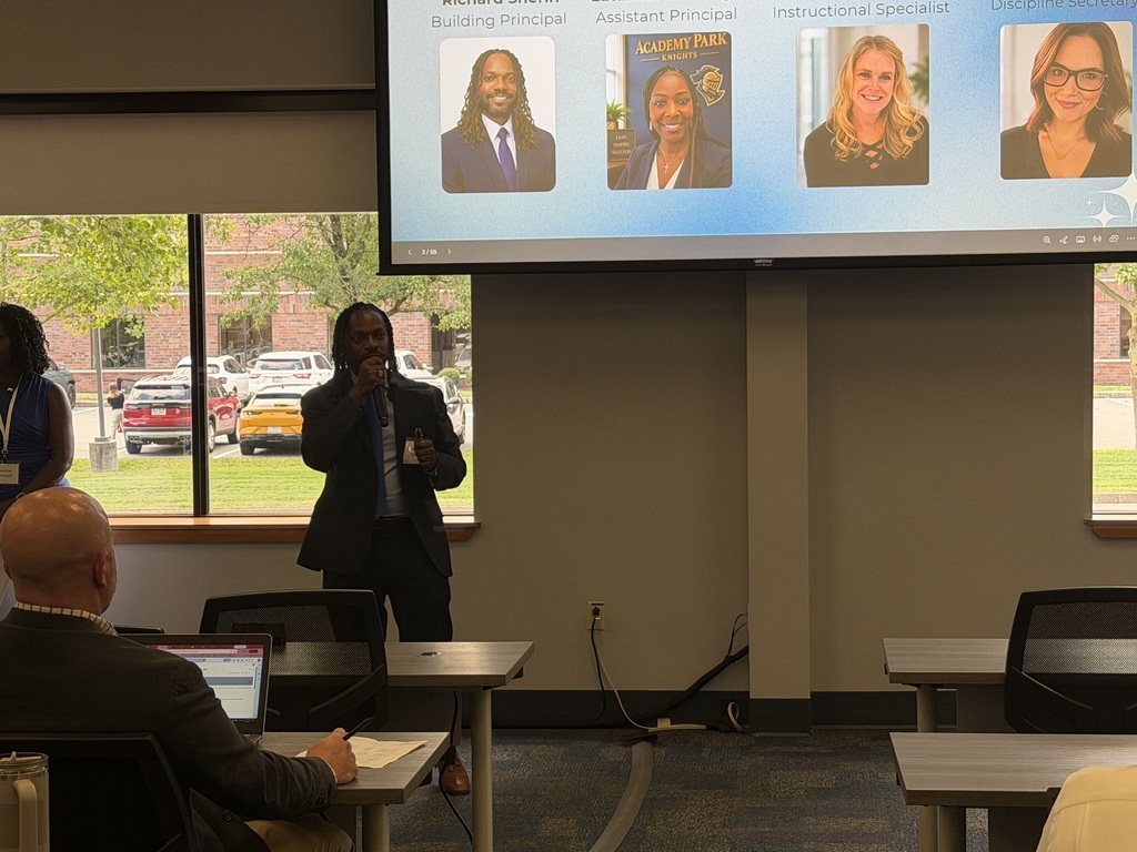 School leader addresses attendees during a professional learning session while presenting an administrative team overview.