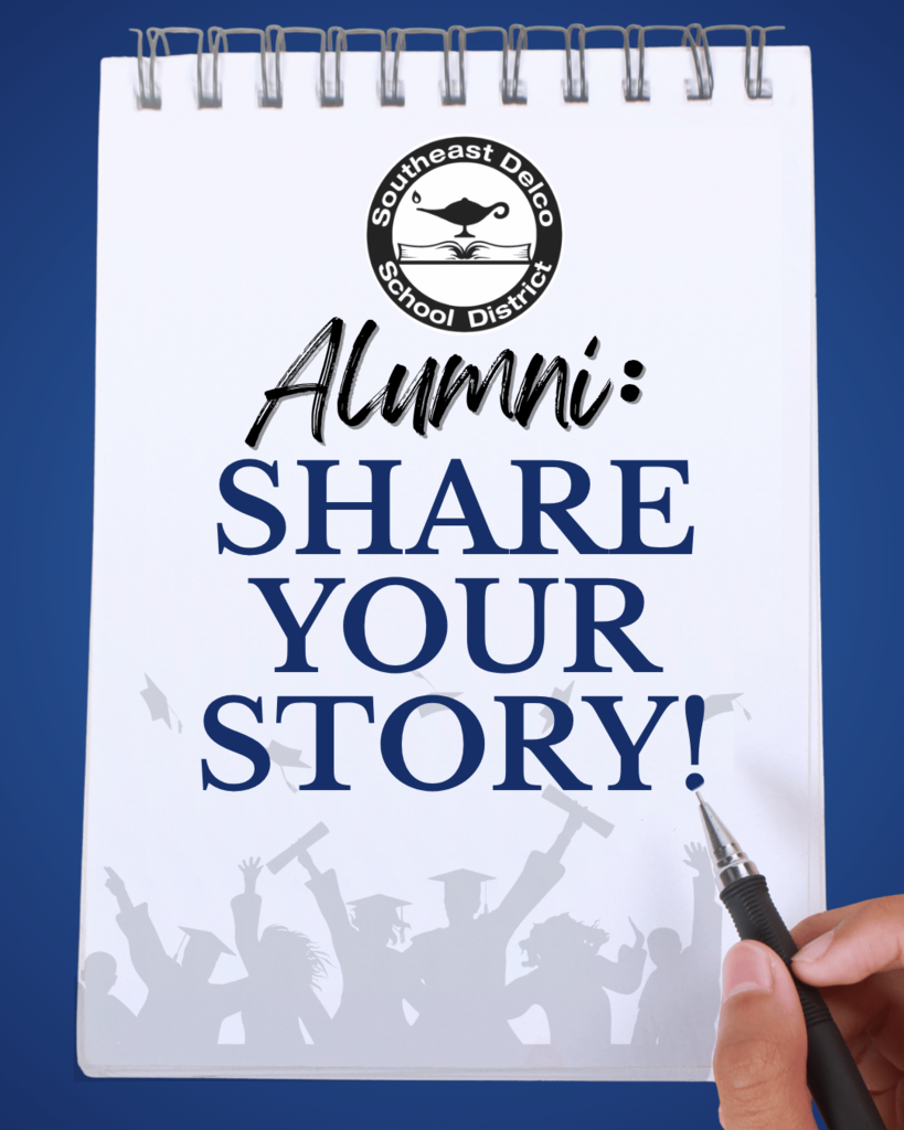Notepad with Southeast Delco School District logo and text urging alumni to share their stories, held by a hand with a pen.