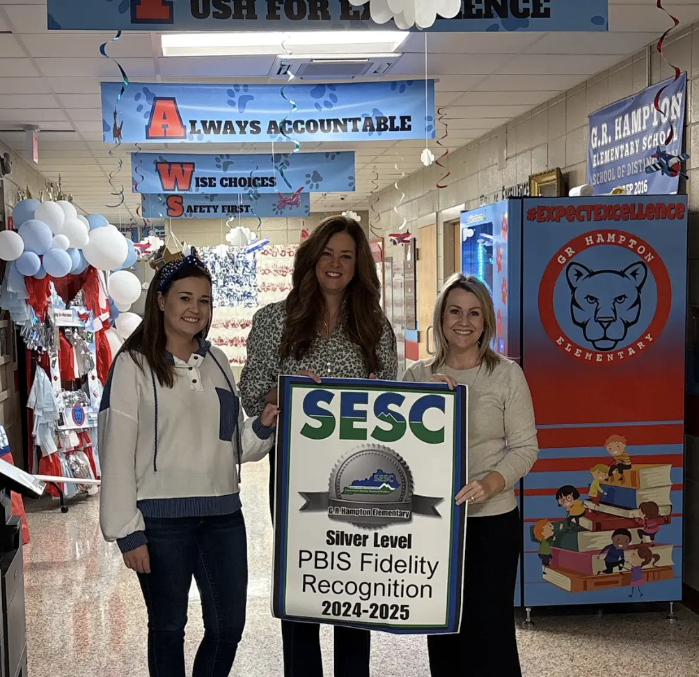 SESC Staff presenting a PBIS Fidelity Banner to GR Hampton staff
