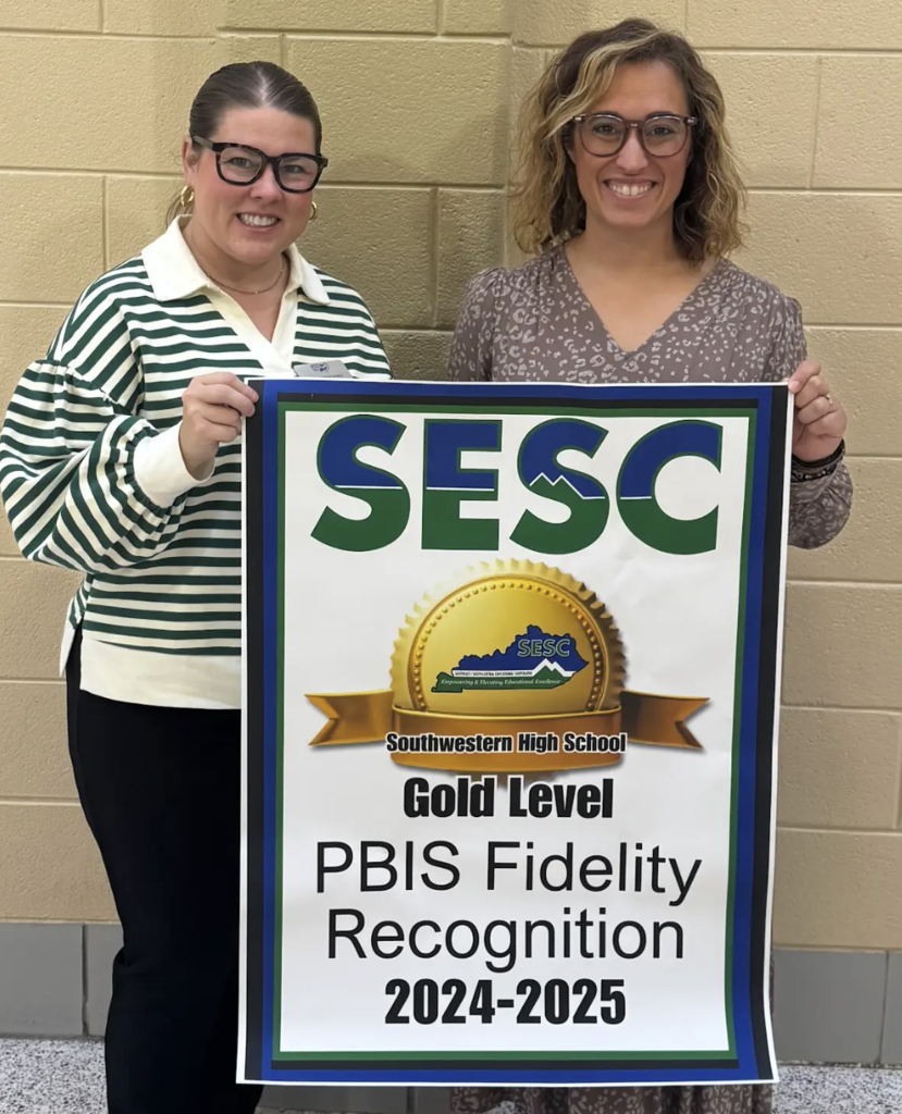 SESC Staff presenting a PBIS Fidelity Banner to Southwestern High school staff
