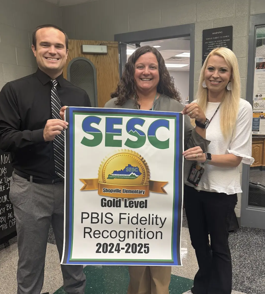 Shopville Elem Staff proudly holding their PBIS banner