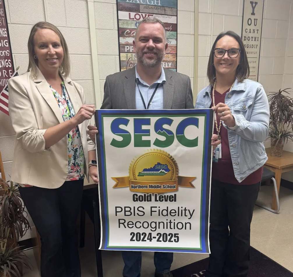 Northern Middle School staff proudly holding their PBIS Fidelity banner