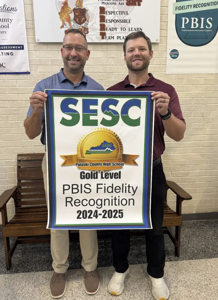 Pulaski County High School staff holding their PBIS Fidelity Banner