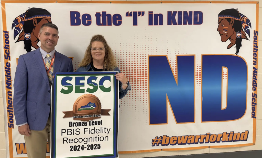 Southern Middle School staff proudly holding their PBIS Fidelity Banner