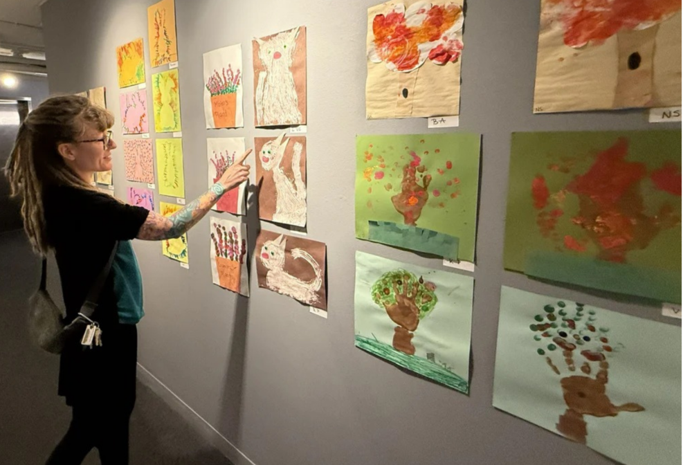 Art instructor looking at artwork display