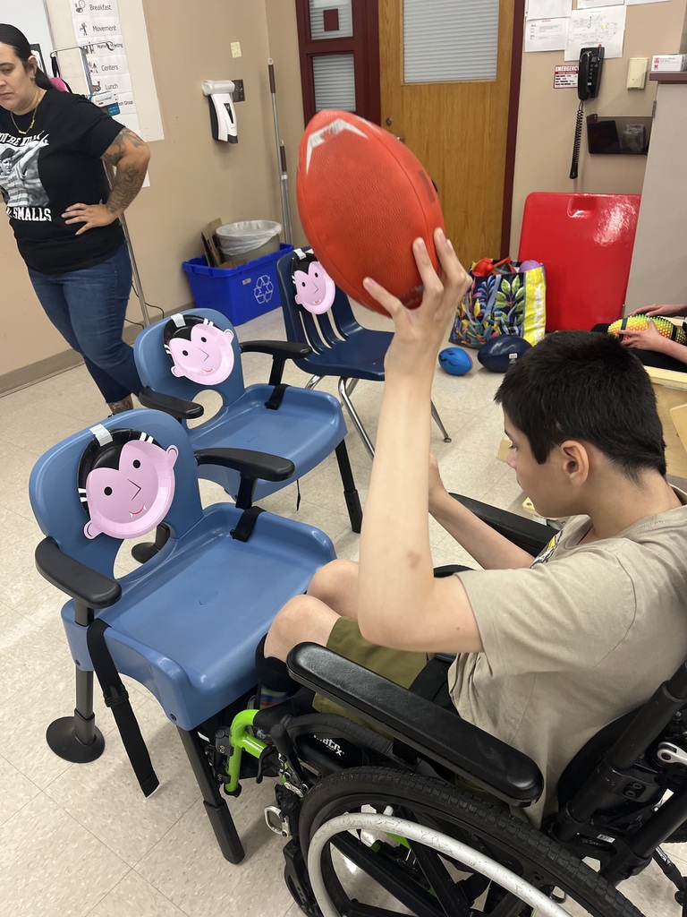Student throwing football toward the dracula target