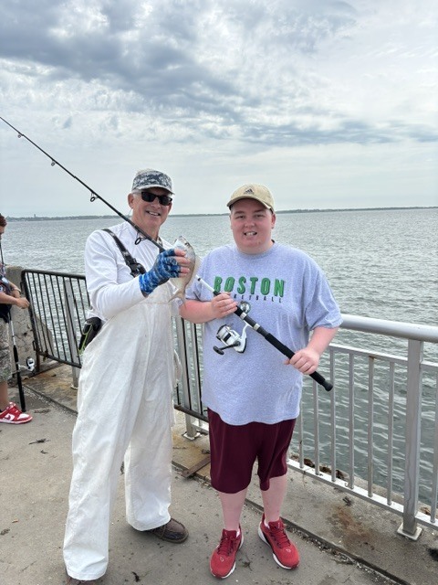 Captain and Student fishing and captain has a fish