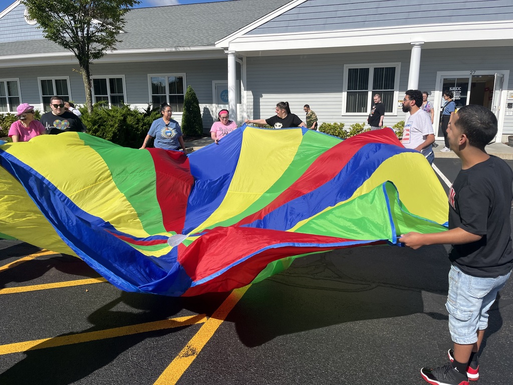 Group of men and women playing a parachute game outside 