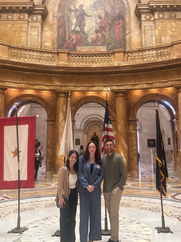 Two teachers standing on the left and right of student at MA Student Government Day in the Massachusetts State House