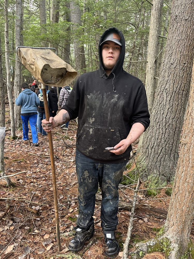 Garret Smith gets an award for getting right in there; students explored a swamp searching for invertebrates 