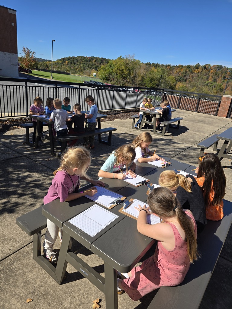 photo of students practicing their writing outdoors