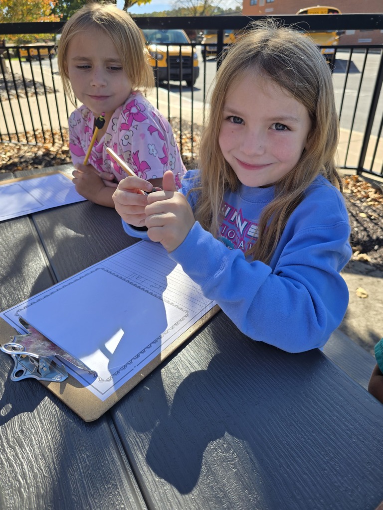 photo of students practicing their writing outdoors