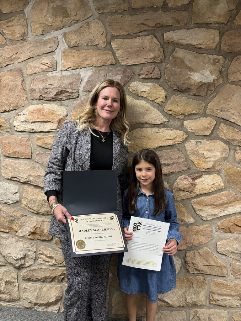 citizen of the month holding a certificate with the superintendent