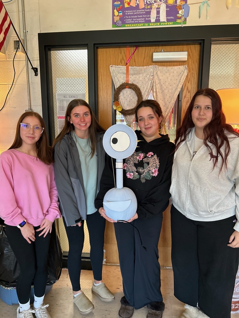 students posing with painted pumpkin
