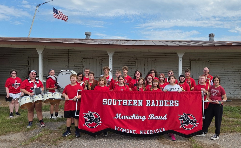 The Southern Band poses behind their banner