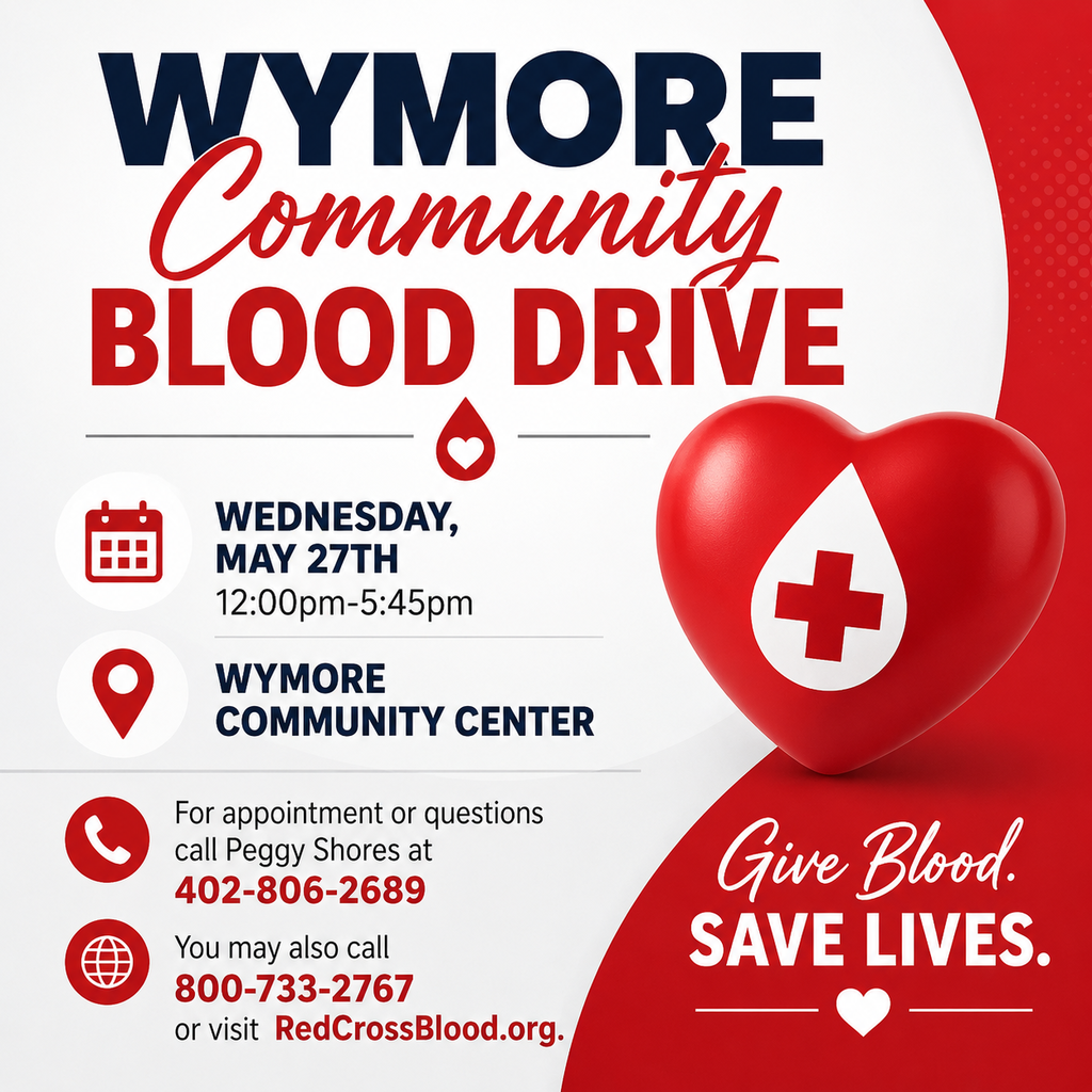 A red, white, and gray promotional graphic for the Wymore Community Blood Drive. The headline reads “Wymore Community Blood Drive” with a red heart and blood drop icon. Event details list Wednesday, May 27th from 12:00pm–5:45pm at the Wymore Community Center. Contact information includes Peggy Shores at 402-806-2689 and an additional number, 800-733-2767, along with the website RedCrossBlood.org. The graphic includes a large red heart with a medical cross and the message “Give Blood. Save Lives.”