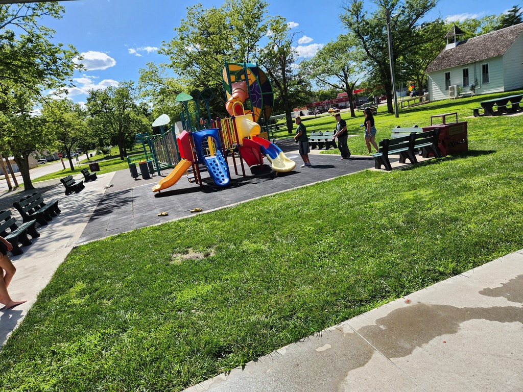 Students at the park trying to dodge water balloons being thrown their way.