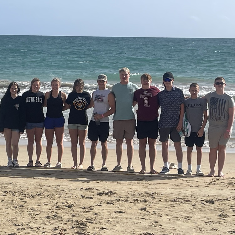 Beach pic of kids on trip in front of the ocean