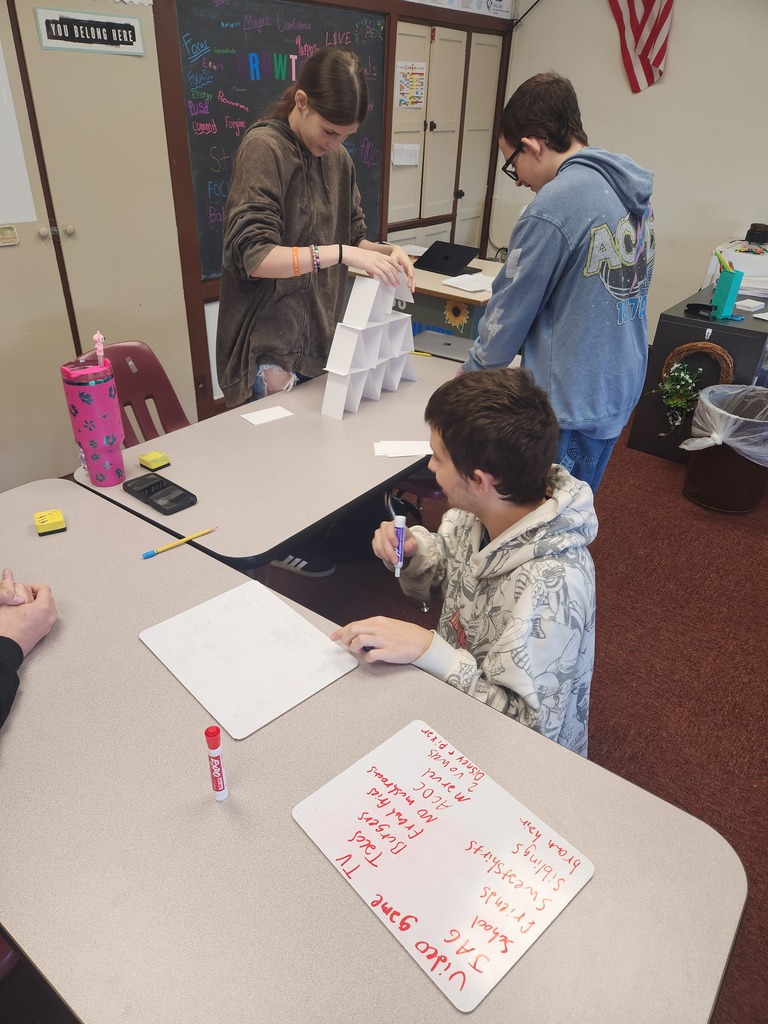 3 students creating their commonality tower out of index cards in a classroom setting