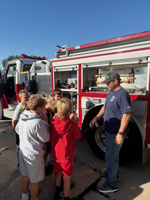 firefighter showing students equipment