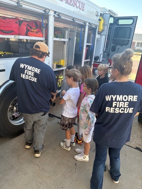 Fire fighters showing students equipment