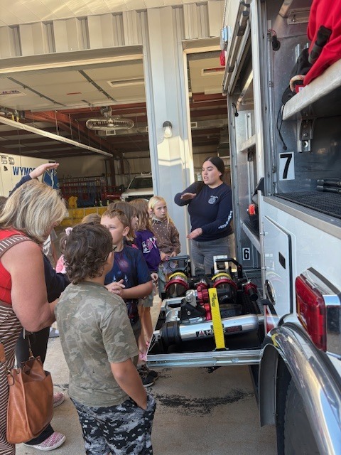 Fire fighter showing students the fire truck