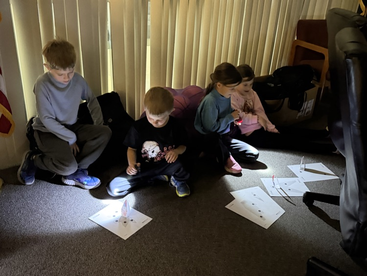 First graders using flashlights to learn about shadows  