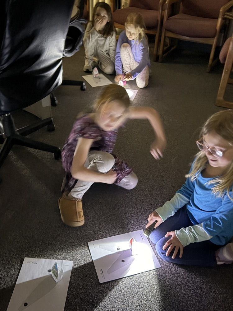 First graders using flashlights to learn about shadows. 